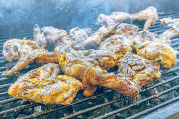 Grilled chicken roasting over hot coals. Juicy meat browning with smoke and fire in an outdoor setting. A traditional meal, perfect for family gatherings and weekend occasions.
