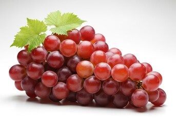 Fototapeta premium A large bunch of ripe red grapes with green leaves on a white fruit cluster