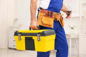 Professional repairman with tool box indoors, closeup
