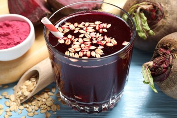 Superfood. Tasty juice with oats in glass and beetroots on light blue wooden table, closeup