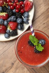 Superfood. Tasty smoothie in glass and ingredients on wooden table, flat lay