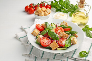 Delicious salad with croutons and ingredients on white wooden table, closeup