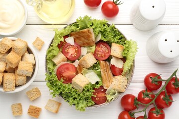 Delicious salad with croutons and ingredients on white wooden table, flat lay