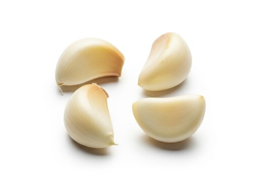 Four peeled garlic cloves arranged in a square on a white food 1