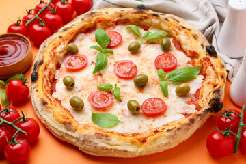 Delicious pizza with tomatoes, basil and olives served on orange background, closeup