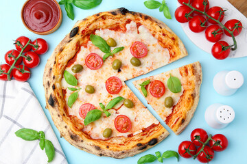 Delicious pizza and ingredients on light blue background, flat lay