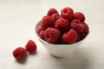Tasty fresh ripe raspberries on white wooden table, closeup