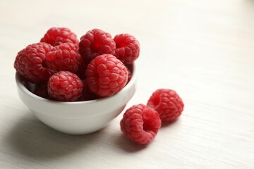 Tasty fresh ripe raspberries on white wooden table, closeup. Space for text