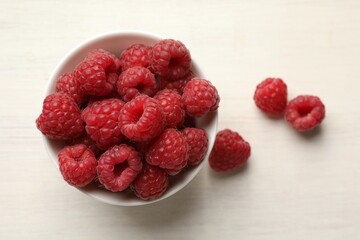 Tasty fresh ripe raspberries on white wooden table, flat lay