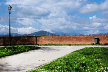 Lucca city walls beautiful park with green grass and old-style streetlamp