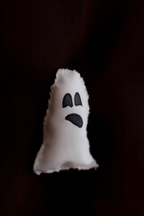 Naklejka premium White ghost plushie hanging on dark background for halloween party decoration