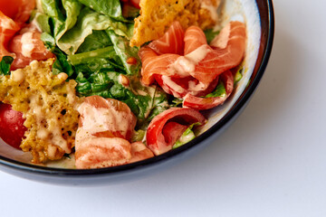 A Colorful Salad Bowl Featuring Fresh Greens, Tomatoes, Salmon, and Crispy Chips Topped with Creamy Dressing for a Delicious Meal Experience