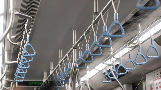 A Singapore MRT train is shown with handrails for standing passengers. Singapore's modern public transport infrastructure.