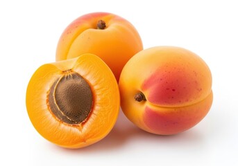 Three ripe apricots one halved showing seed on white fruit food