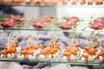 Catering preparing delicious cherry tomato and mozzarella skewers for wedding reception