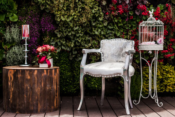Silver chair, flowers, and birdcage creating a romantic wedding atmosphere