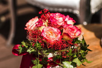 Wedding bouquet sitting on a table with red and pink roses