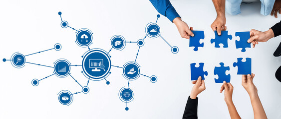 Engaging teamwork in a modern workspace as people collaborate by connecting blue puzzle pieces with...