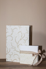 Elegant wedding album and invitation resting on wooden table