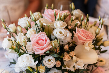 Wedding bouquet of pink and white roses decorating reception table