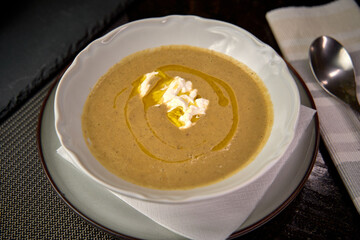 A Warm Bowl of Creamy Soup Drizzled with Olive Oil and Topped with a Dollop of Cream, Perfect for Comforting Meals or Seasonal Gatherings.