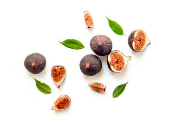 Purple ripe figs fruit and slices with green leaves top view on a white background