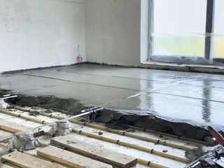 Floor screeding with cement over heated pipes.