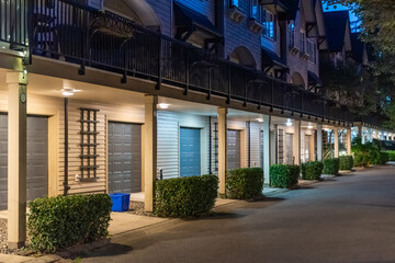Garage door in luxury house with trees and nice landscape in Spring in Vancouver, Canada, North America. Night time on May 2025.