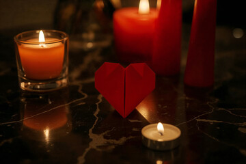 Red origami heart with lit candles on a dark marble surface Keywords: heart, origami, paper, red, love, romance, Valentine's Day, celebration