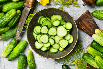 Fresh Green Cucumber Slices in Ceramic Bowl for Food Styling. On a stone table background. Top view.