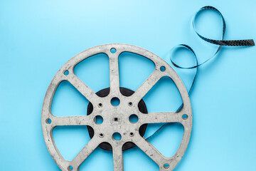 Old 35mm motion picture film reel on blue background. Cinema concept