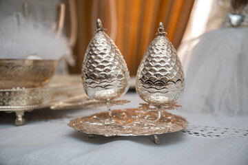 Elegant silver vessels showcase exquisite craftsmanship in a beautifully arranged setting at a cultural event