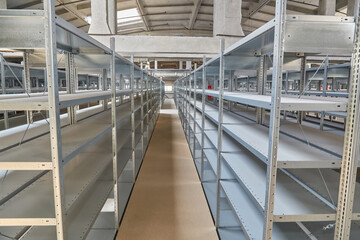 Fototapeta premium Empty Metal Shelving Units in Warehouse Aisle