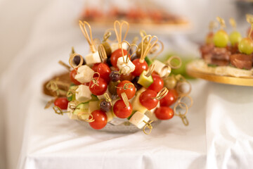 Colorful skewered vegetables on display at a festive gathering in a sunlit hall