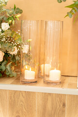 Vibrant floral arrangement accompanied by glowing candles set in elegant glass holders for a cozy atmosphere
