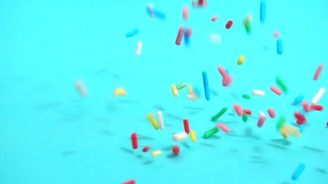 beautiful slow fall of bright sprinkles against tranquil blue backdrop, creating playful and charming scene for any project