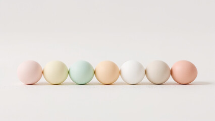 Seven pastel colored Easter eggs arranged in a row on a white background colors