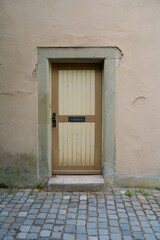 Schmale Holzt&uuml;r mit Briefschlitz im Steinrahmen einer Altstadtfassade