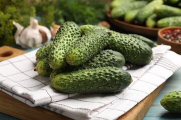 Making pickles. Fresh cucumbers and other ingredients on light blue wooden table, closeup