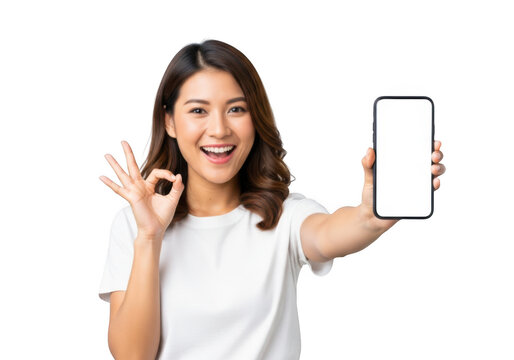 Happy young asian woman holding a blank smartphone and showing ok gesture, isolated on transparent background