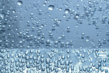 Soda water with bubbles of gas in glass, closeup