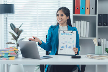 Office Presentation: A composed professional woman presents financial reports during a virtual business meeting, showcasing a modern office setting.