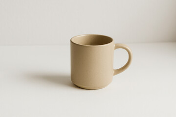 Beige mug on white surface.