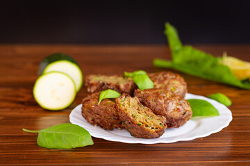 Portioned vegetable muffins with herbs on a dark wooden table