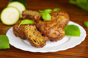Healthy vegetable muffins with herbs and zucchini on a dark wooden table