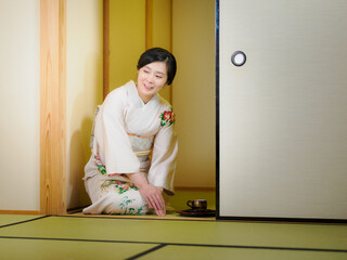お茶をお出しする着物の女性