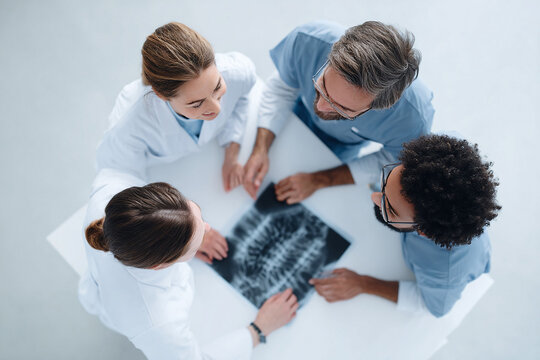Four doctors collaborate, reviewing an Xray. Teamwork in medicine. Top view showing partnership, expertise, and healthcare analysis. Ideal for medical content. - Powered by Adobe