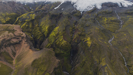 Aerial View of Moss Covered Canyons, Waterfall, and Glacier in Iceland