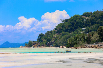 Tropical Beach Scene with Lush Green Hillside and Turquoise Waters