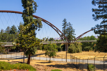 A rust colored suspension bridge at Happy Hollow Park and Zoo in in San Jose California USA